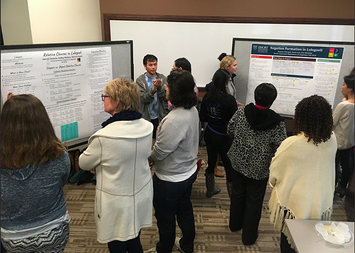 Students presenting their research on Negation formation in Lulogooli. Seaira Lett, Melanie Fabregas, Julie Wechsler. Poster, students and faculty.