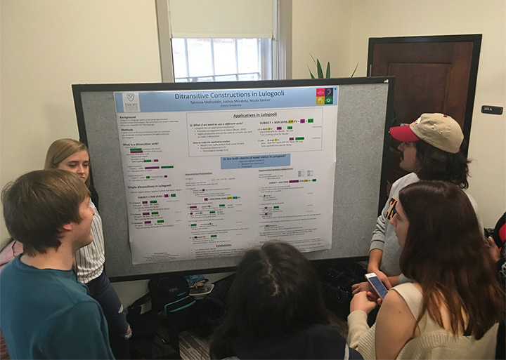 photo of students presenting research on Ditransitive constructions in Lulogooli. Daisy Mohiuddun, Joshua Morabito, Nicole Steiner. Photo also includes poster, students and faculty.