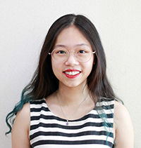 Giang Dang is a peer mentor for LING 201, she is standing in front of a white background, smiling and looking forward.